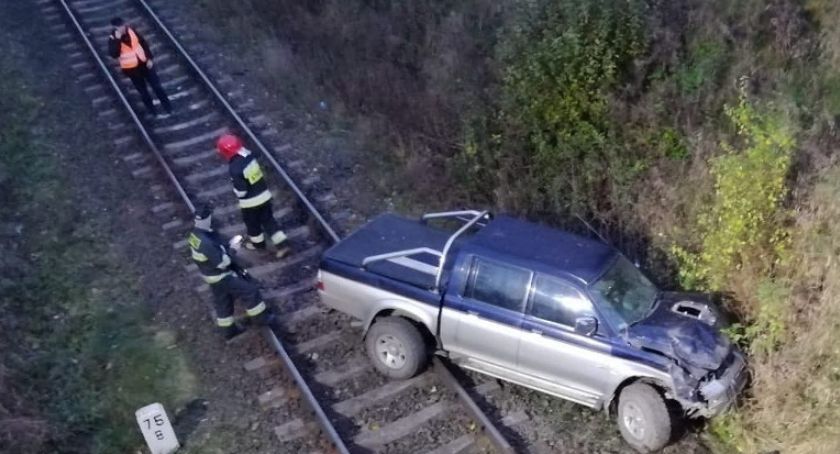 Samochód spadł z wiaduktu na tory kolejowe. Kierowca zasnął za kierownicą [FOTO]